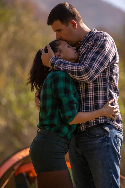 Чоловік цілує свою дівчину на голові на гірському тлі — стокове фото
