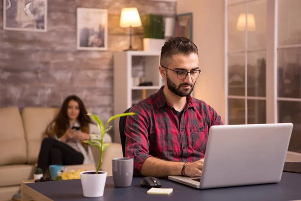 Freelancer barbudo trabalhando no laptop na sala de estar — Fotografia de Stock