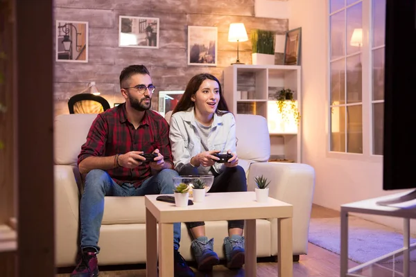 Genç çift televizyonda video oyunu oynarken iyi vakit geçiriyor. — Stok fotoğraf
