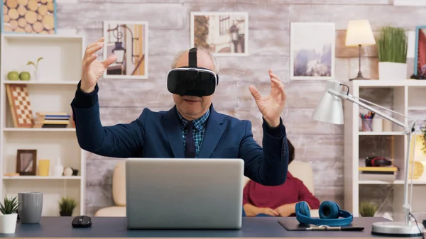 Senior man using virtual reality goggles in living room — Stock Photo, Image