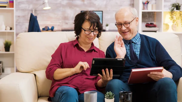 Oudere echtpaar zwaaiend naar tablet tijdens een videogesprek — Stockfoto