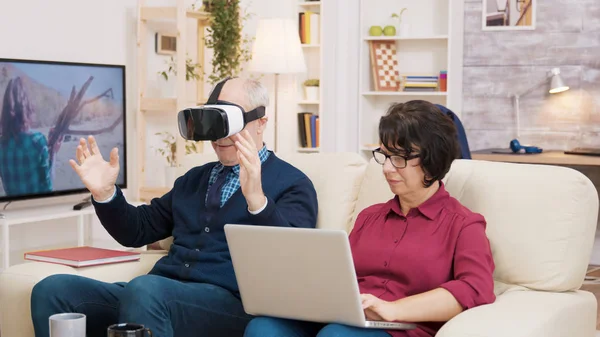 Oudere leeftijd vrouw zitten op de bank met behulp van laptop — Stockfoto