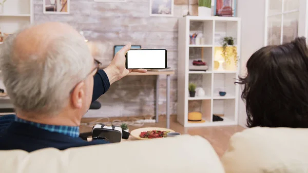 Zadní pohled na starší pár při pohledu na telefon se zelenou obrazovkou — Stock fotografie