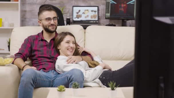 Couple sitting on the couch and laughing — Stockvideo