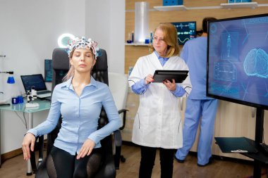 Bilimsel bir laboratuvarda kızların beyin taraması yapan bir doktor.