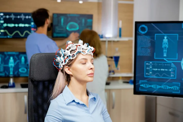 Paciente feminina digitalizando seu cérebro com fone de ouvido de neurologia — Fotografia de Stock