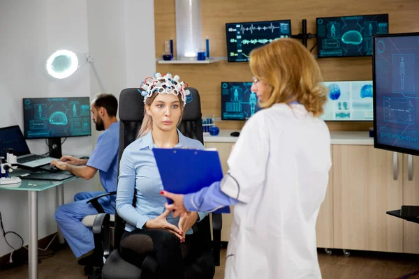 Paciente feminina com dispositivo de varredura de ondas cerebrais olhando para uma área de transferência — Fotografia de Stock