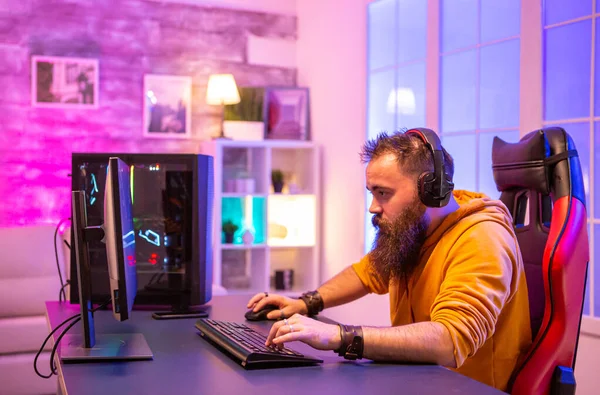 Geconcentreerde bebaarde gamer op zoek naar Pc display — Stockfoto