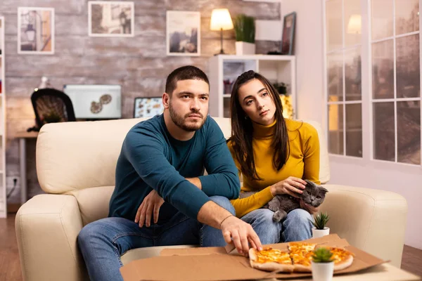 Lindo jovem casal comer pizza enquanto assistindo TV — Fotografia de Stock