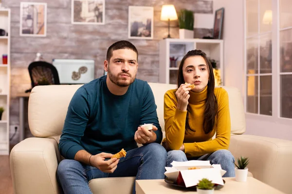 Junges Paar isst gebratenes Huhn vor dem Fernseher — Stockfoto