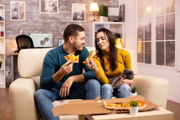 Lindo jovem casal comer pizza enquanto assistindo TV — Fotografia de Stock