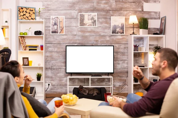 Пара дивиться на ізольований екран телевізора в затишній вітальні — стокове фото