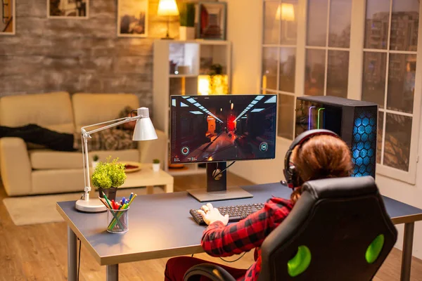 Visão traseira do jogador feminino jogando no PC computador poderoso tarde da noite na sala de estar — Fotografia de Stock