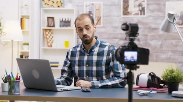 Известный молодой блоггер печатает на ноутбуке во время разговора — стоковое видео