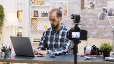 Konuşurken dizüstü bilgisayarda yazan ünlü genç vlogger