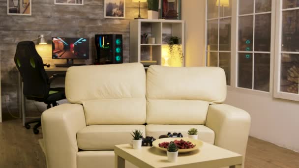 Habitación vacía con sofá en el medio y computadora de juego tarde en la noche — Vídeos de Stock