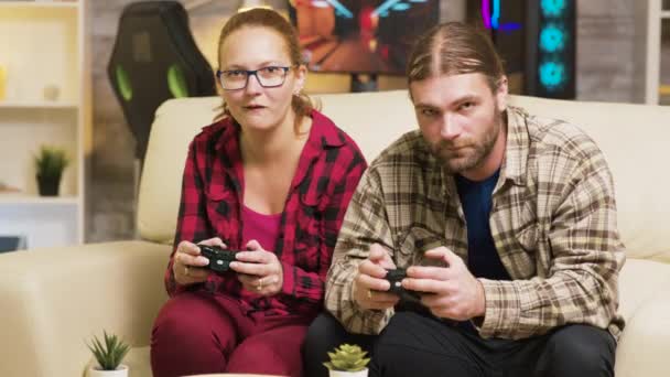 Fokussiertes Paar, das Online-Videospiele auf der Couch spielt — Stockvideo