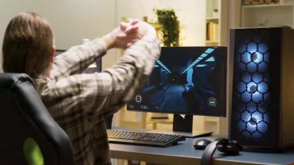 Man stretching voordat u begint om videospelletjes te spelen op de computer — Stockvideo