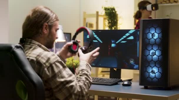 Man houdt zijn hoofd op het bureau na het verliezen bij videospelletjes op de computer — Stockvideo