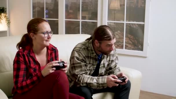 Женщина толкает парня после их потери, играя в видеоигры — стоковое видео