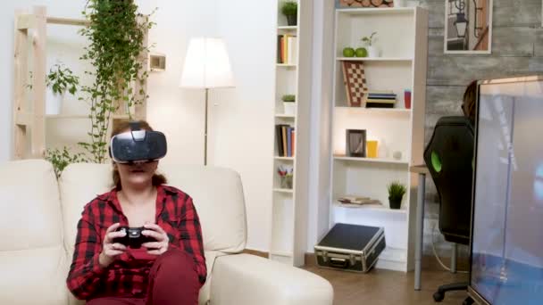 Молодая женщина в VR-гарнитуре во время игры в видеоигры — стоковое видео