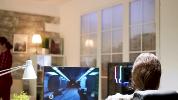 Professionele gamer met lang haar zet zijn hoofdtelefoon met een microfoon op — Stockvideo
