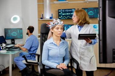Bilimsel bir laboratuvarda kızların beyin taraması yapan bir doktor.