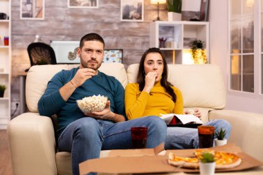 Güzel, genç bir çift televizyon izliyor ve fast food servisi yapıyorlar.