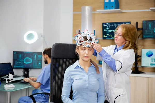 Docteur qui met un scanner d'ondes cérébrales sur une patiente — Photo