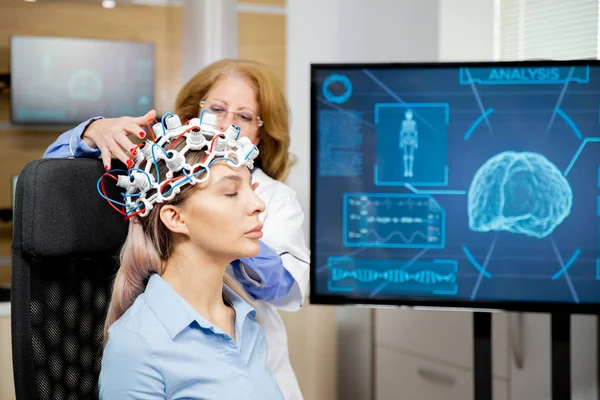 Γιατρός τακτοποίηση συσκευή σάρωσης στο κεφάλι μιας γυναίκας ασθενή — Φωτογραφία Αρχείου