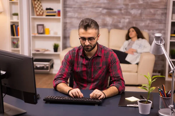 Freelancer barbudo escribiendo en el ordenador mientras trabaja desde casa — Foto de Stock