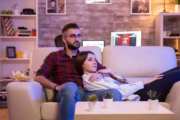 Belo jovem casal assistindo seu programa de tv favorito — Fotografia de Stock