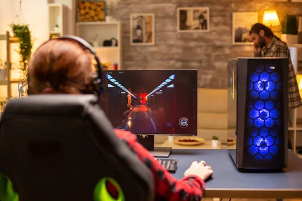 Πίσω όψη του θηλυκού gamer παίζει σε ισχυρό υπολογιστή Pc αργά το βράδυ στο σαλόνι — Φωτογραφία Αρχείου