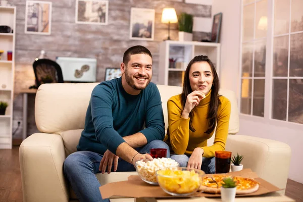 Krásný mladý pár sledování televize a jíst rychlé občerstvení — Stock fotografie