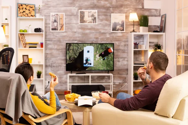 Zadní pohled na pár v obývacím pokoji sledování filmu na televizoru — Stock fotografie