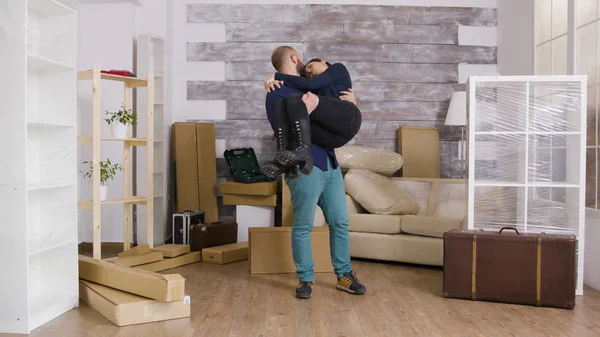 Heyecanlı erkek arkadaş yeni dairesinde kız arkadaşına omuz atıyor. — Stok fotoğraf