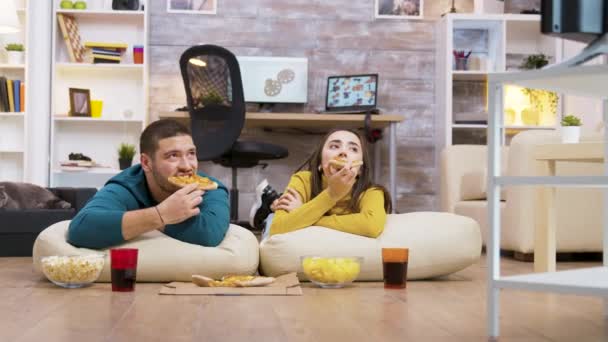 Boldog kaukázusi pár eszik pizza ül a párnán — Stock videók