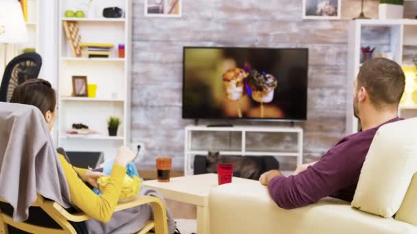 Jovem casal sentado confortável na frente da tv — Vídeo de Stock