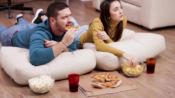 Молода подружня пара дивиться страшний фільм по телевізору — стокове відео
