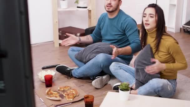 Cheerful young couple sitting on the floor — ストック動画