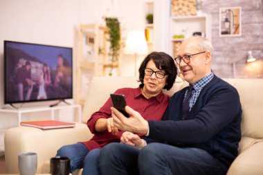 Yaşlı Eldelry çifti aileleriyle konuşmak için akıllı telefon kullanıyor.