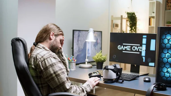 Игра окончена для человека, сидящего на игровом стуле с помощью гарнитуры VR — стоковое фото