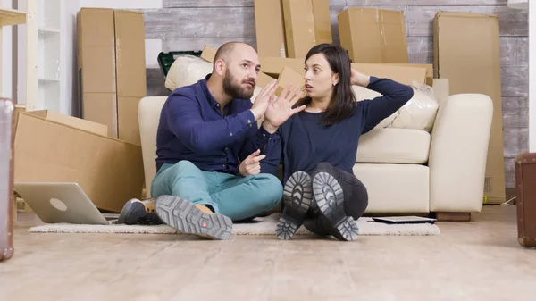 Молодая кавказская пара, сидящая на полу своей новой квартиры — стоковое фото