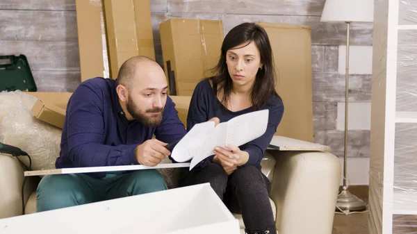 Молодая пара спорит во время сборки мебели в своей новой квартире — стоковое фото