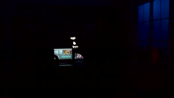 Man loopt de kamer binnen, doet de lichten aan met een slimme lichtapplicatie — Stockvideo