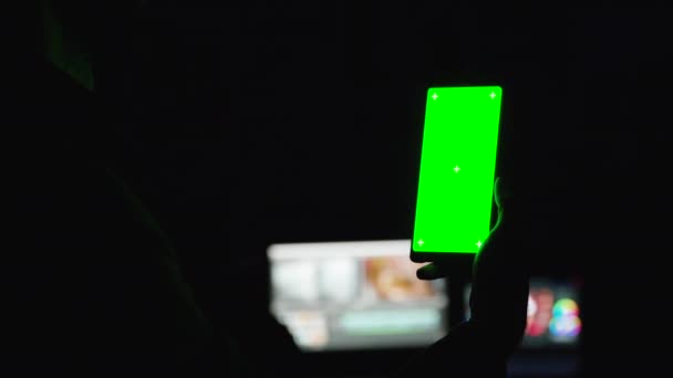 Μεγέθυνση σε πλάνο του ανθρώπου τρύπα ένα smartphone με πράσινη οθόνη mock-up — Αρχείο Βίντεο
