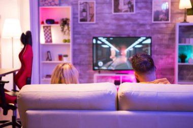 Kanepede oturup online video oyunları oynayan genç çiftin arka plan görüntüsü