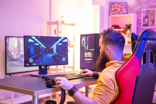 Homem barbudo jogando jogos de vídeo online em seu PC — Fotografia de Stock