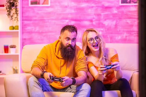 Beautiful blonde girl smiling while playing video games — Stock Photo, Image