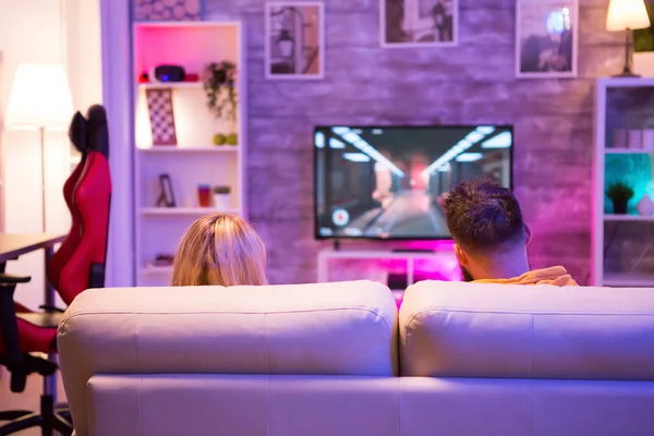 Вид на молодую пару, сидящую на диване и играющую в онлайн-игры — стоковое фото